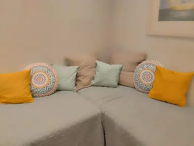 a white couch with colorful pillows on it at Ermou 44 - 2bdr apartment in Athens