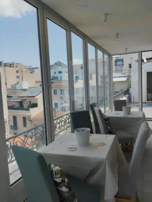 a dining room with tables and chairs and windows at Ermou 44 - 2bdr apartment in Athens