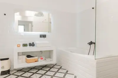 a bathroom with a tub and a sink and a mirror at Artistic Luxury with Acropolis View in Psirri Monastiraki in Athens