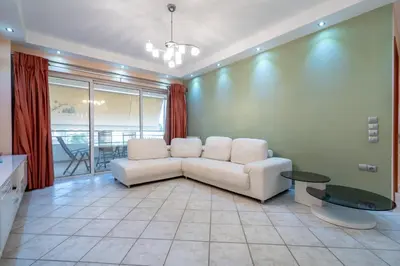 a living room with a white couch and a table at Elysian Sky Suite 421 in Athens