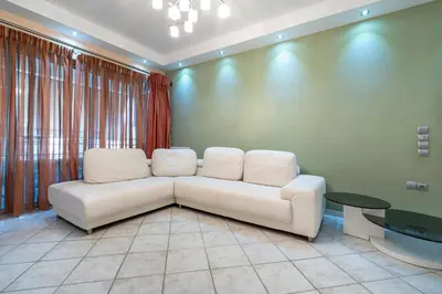 a living room with a white couch and a table at Elysian Sky Suite 421 in Athens