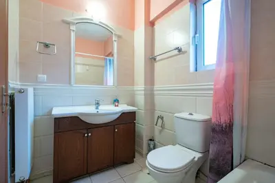 a bathroom with a toilet and a sink and a mirror at Elysian Sky Suite 421 in Athens