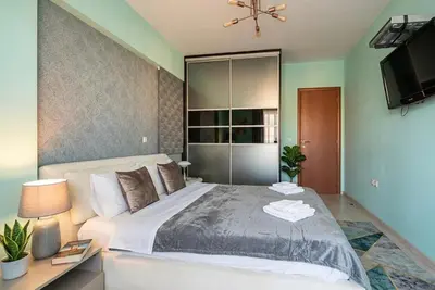 a bedroom with a large bed and a television at Elysian Sky Suite 421 in Athens