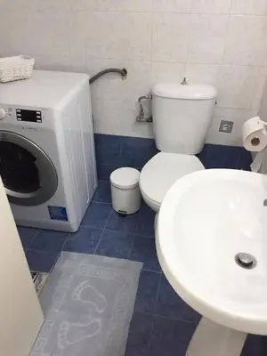 a bathroom with a toilet and a sink and a washing machine at Beautiful apartment under Acropolis in Athens