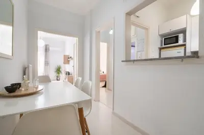 a white dining room with a white table and chairs at Beautiful apartment under Acropolis in Athens