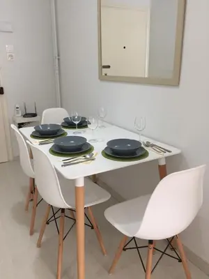 a white dining table with white chairs and a mirror at Beautiful apartment under Acropolis in Athens