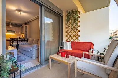 a balcony with a red couch and a living room at Athens City Easy Move - Patissia by ΜΡS in Athens