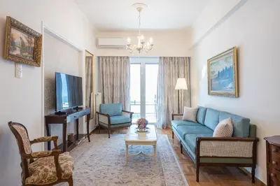 a living room with a blue couch and a tv at Sun-Kissed Koukaki Apartment City Views in Athens