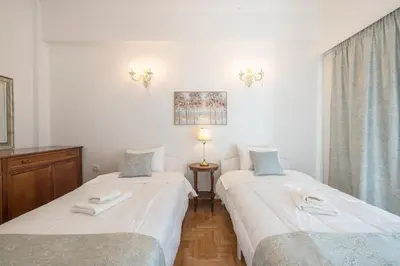 two beds sitting next to each other in a room at Sun-Kissed Koukaki Apartment City Views in Athens