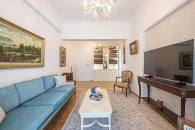 a living room with a blue couch and a flat screen tv at Sun-Kissed Koukaki Apartment City Views in Athens