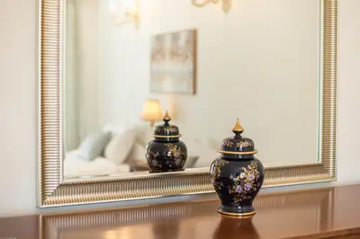 a vase sitting on a table in front of a mirror at Sun-Kissed Koukaki Apartment City Views in Athens