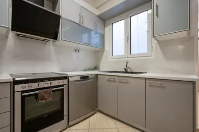 a white kitchen with a stove and a sink at Central Nea Smyrni 2BR Apt-Near Transport by ΜΡS in Athens