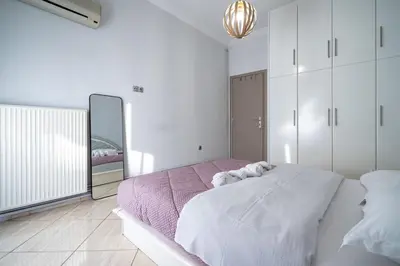a white bedroom with a large bed and a mirror at Central Nea Smyrni 2BR Apt-Near Transport by ΜΡS in Athens