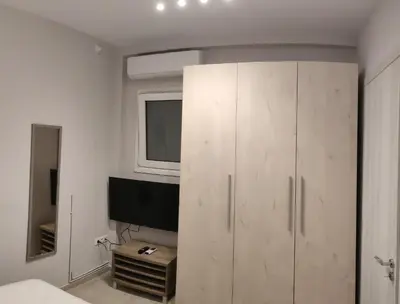 a bedroom with a white cabinet and a television at Dream House Egaleo in Athens