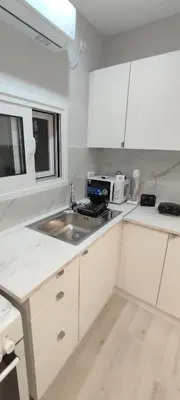 a white kitchen with a sink and a microwave at Dream House Egaleo in Athens