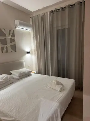 a bedroom with a bed with white sheets and a window at home 4 in Athens
