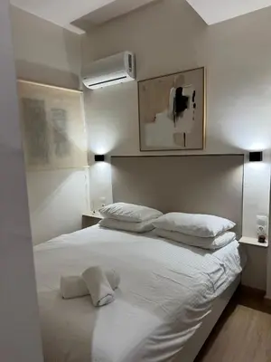 a bedroom with a large white bed with two pillows at home 4 in Athens