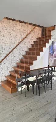a dining room with a table and chairs and stairs at Kalisti House2Heal Athens in Athens
