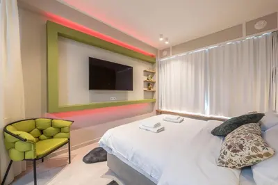 a bedroom with a bed and a chair and a television at Acropolis View Dream Stay nr 5 in Athens