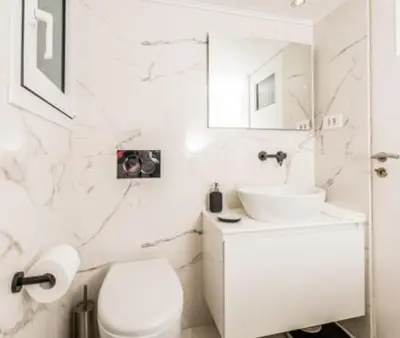 a white bathroom with a toilet and a sink at Flat White in Athens
