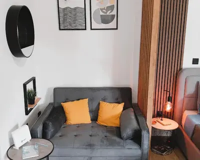 a living room with a black leather couch with yellow pillows at Sky Garden, penthouse in Athens in Athens