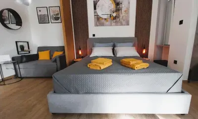 a bedroom with a bed with two yellow pillows on it at Sky Garden, penthouse in Athens in Athens