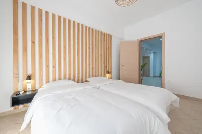 a bedroom with a large bed with white sheets at Athenian home near Acropolis in Athens