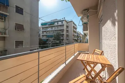 a balcony with a wooden table and chair on a building at Athenian home near Acropolis in Athens