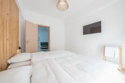 a white bedroom with a large white bed at Athenian home near Acropolis in Athens
