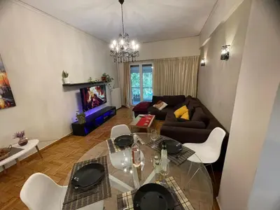 a living room with a glass table and a couch at Minimal Central 2BR in Athens