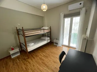 a room with two bunk beds and a table at Minimal Central 2BR in Athens