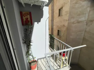 a balcony with a plant on the side of a building at Minimal Central 2BR in Athens