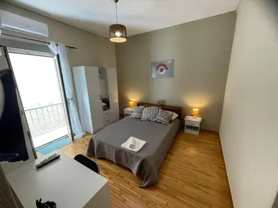 a bedroom with a bed and a large window at Minimal Central 2BR in Athens