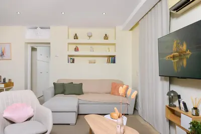 a living room with a couch and a tv at Glyfada Cove Apartments-Ostria in Athens