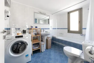 a bathroom with a washing machine and a sink at Glyfada Cove Apartments-Ostria in Athens