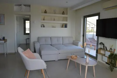 a living room with a couch and a table at Glyfada Cove Apartments-Ostria in Athens
