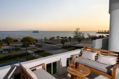 a balcony with a couch and a view of the ocean at Glyfada Cove Apartments-Ostria in Athens