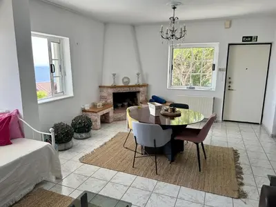 a living room with a dining room table and a couch at Art Blue Residence-Apartment Athens in Aghia Marina