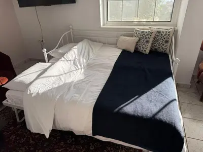 a bed with a black and white blanket and a window at Art Blue Residence-Apartment Athens in Aghia Marina