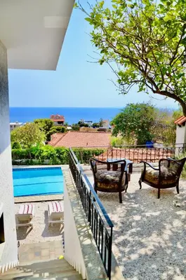 a patio with chairs and a swimming pool at Art Blue Residence-Apartment Athens in Aghia Marina