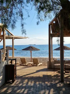 a beach with chairs and umbrellas and the ocean at Art Blue Residence-Apartment Athens in Aghia Marina