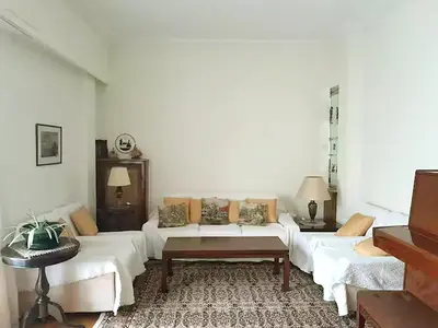 a living room with a white couch and a table at Victoria Flat in Athens