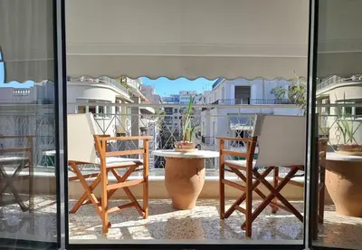 a table and chairs on a balcony with a view at Victoria Flat in Athens