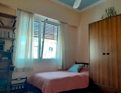 a small bedroom with a bed and a window at Victoria Flat in Athens