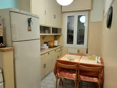a kitchen with a table and a refrigerator at Victoria Flat in Athens
