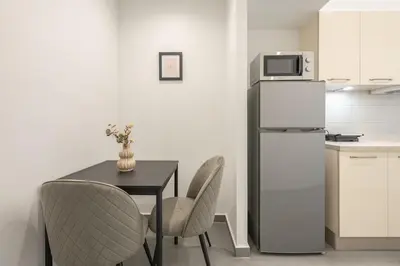a kitchen with a table and chairs and a refrigerator at Minimal Harmony Apartment - Nea Smyrni by ΜΡS in Athens