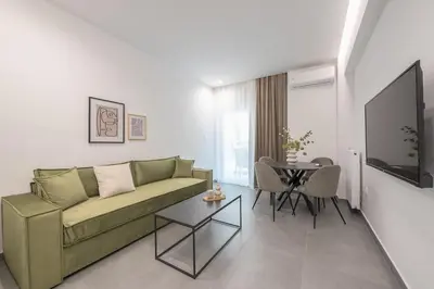 a living room with a green couch and a table at Minimal Harmony Apartment - Nea Smyrni by ΜΡS in Athens