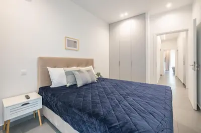 a bedroom with a large bed with a blue blanket at Minimal Harmony Apartment - Nea Smyrni by ΜΡS in Athens