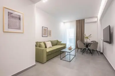 a living room with a green couch and a table at Minimal Harmony Apartment - Nea Smyrni by ΜΡS in Athens