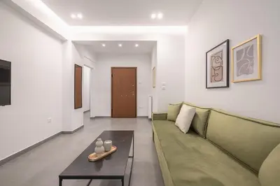 a living room with a green couch and a table at Minimal Harmony Apartment - Nea Smyrni by ΜΡS in Athens